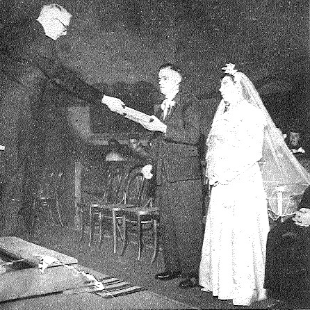 After the church blessing, the bridal couple receives a Bible from the hands of Rev. A.A. Oostenbrink. 