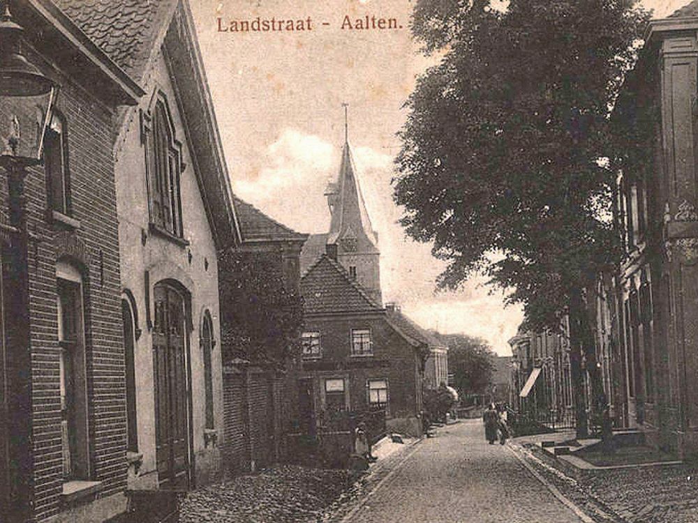 Aan de Landstraat was het achtererf van het pand Markt 18 afgesloten met een bakstenen tuinmuur, links in beeld. Links daarvan zien we het koetshuis (foto uit ca. 1917)